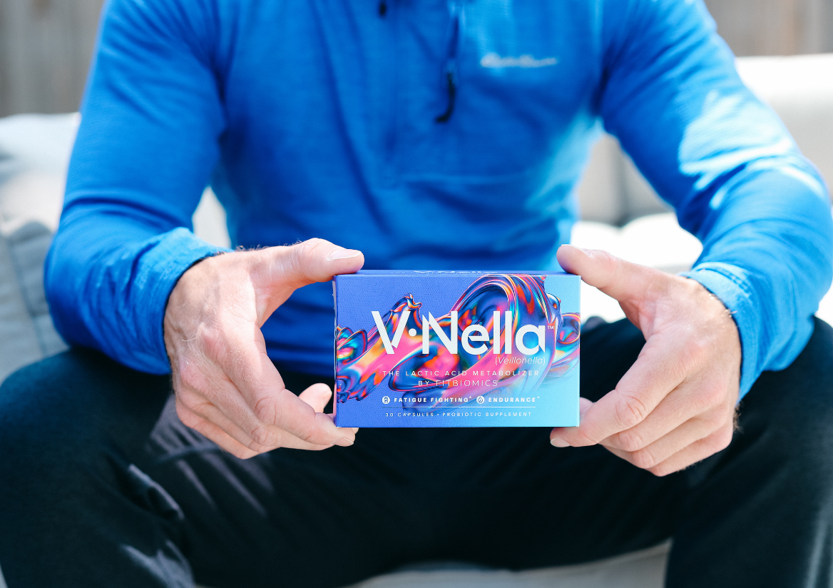 man in a blue jacket holding  box of v•nella with two hands out in front of him