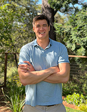 nathan adrian standing with her arms crossed and smiling